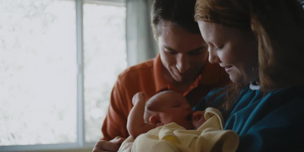 A couple hold their newborn
