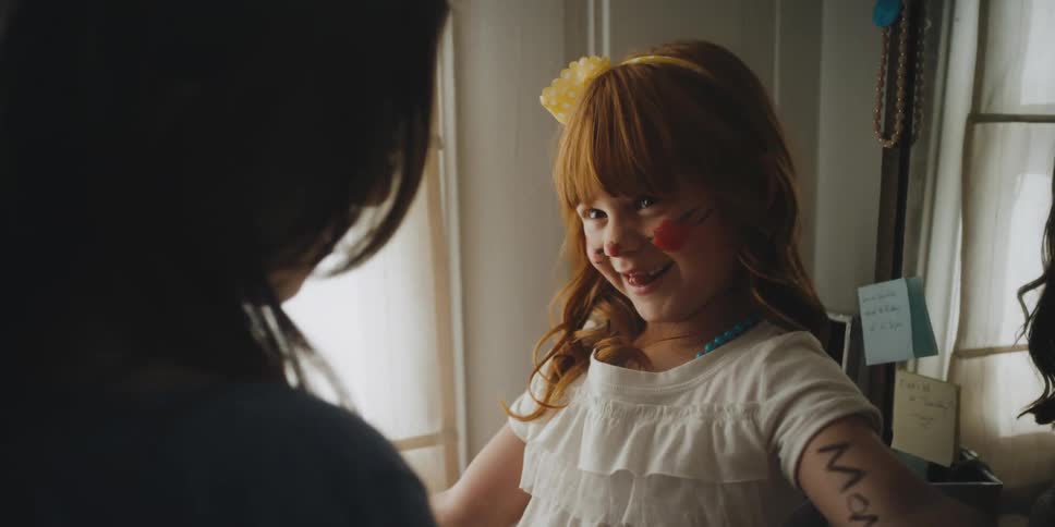 A mother and little girl are playing in a bedroom