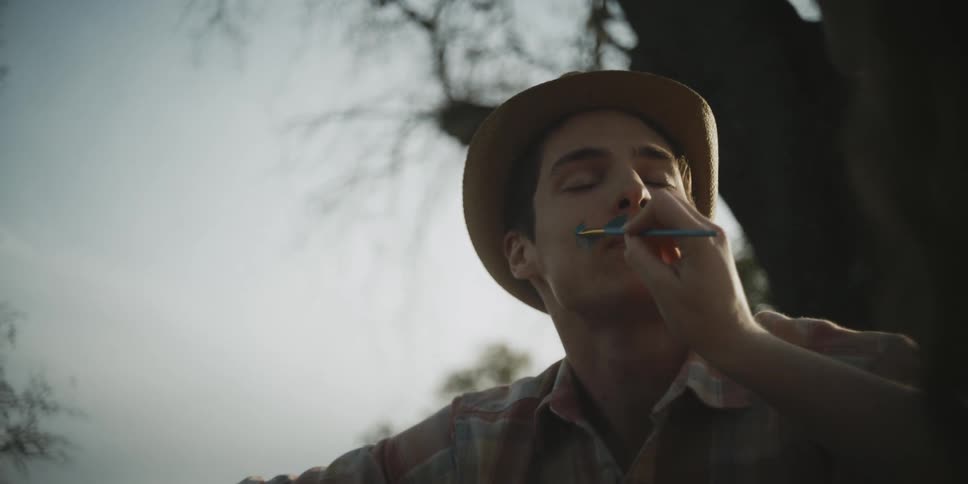 Woman draws on a man's face with a pencil