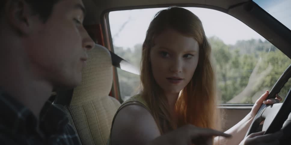 Woman listening while man teaches her to drive car