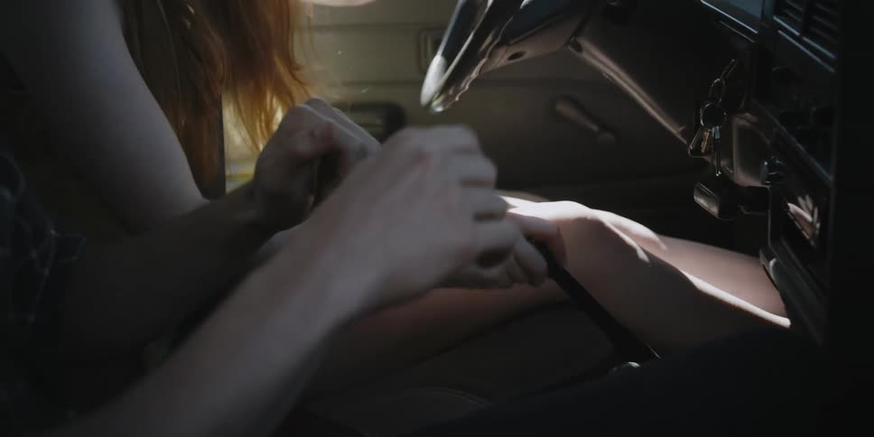 A woman is taught how to drive a manual transmission car