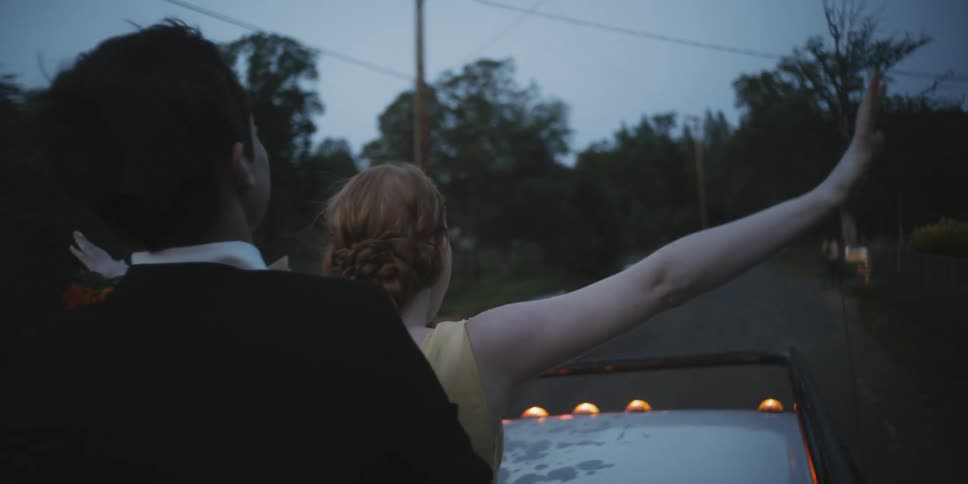 Teenagers dressed for prom ride in the back of a pickup truck