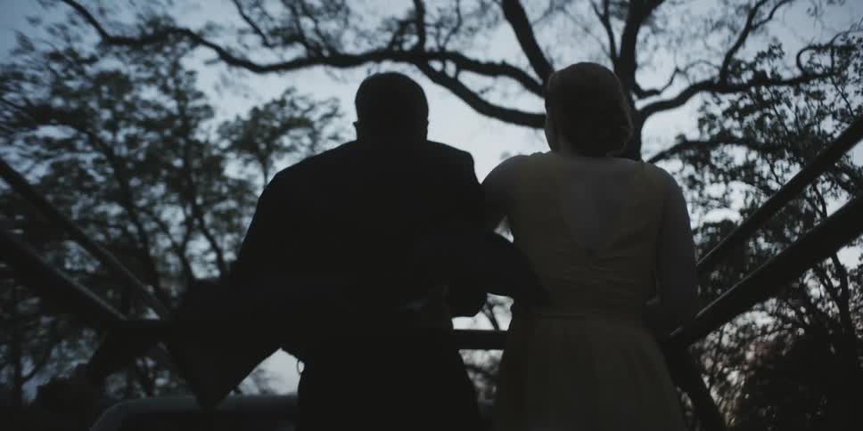 A man and woman ride on the back of a pickup