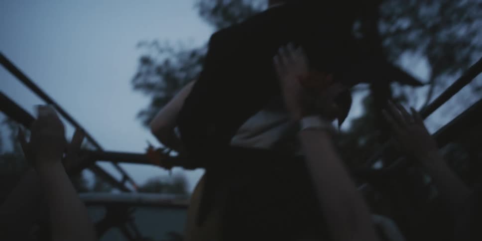 Teenagers dressed for prom ride in the back of a pickup truck at dusk