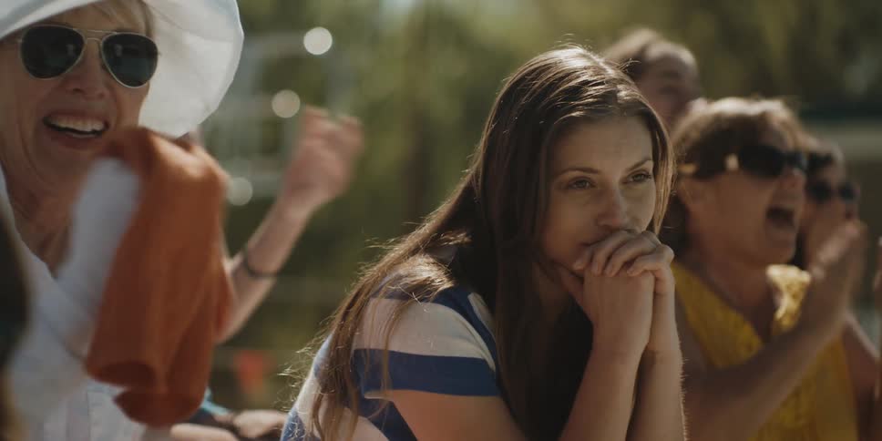 People are sitting together cheering on a sunny day
