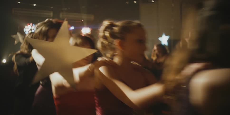People jump and dance with lights flashing on them