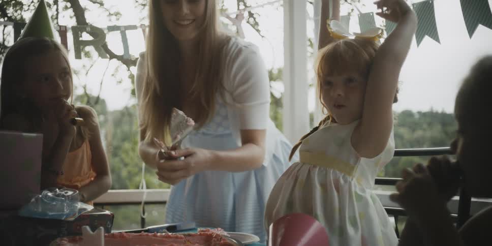 A woman and young girls celebrate at a birthday party