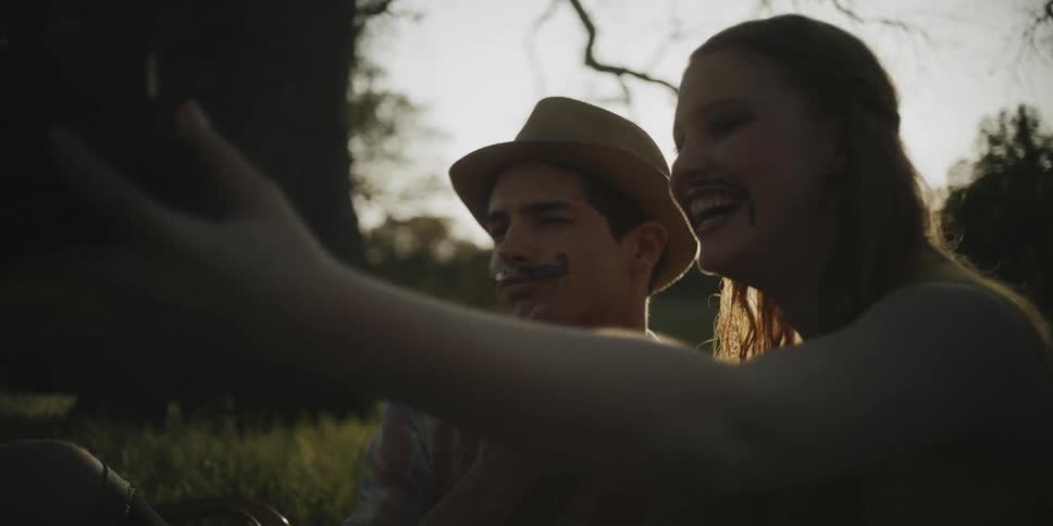 A man and woman are laughing and posing as they take a selfie