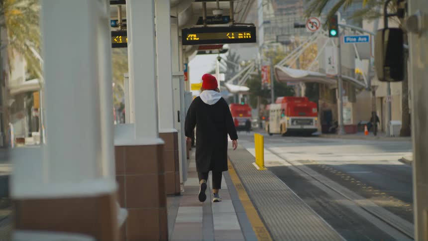 A person walks through a street car station in a city during the day