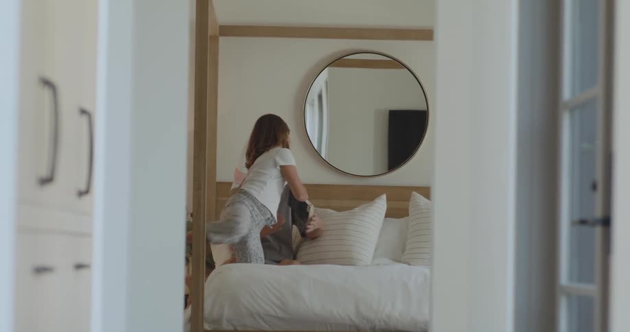 A child runs in the bedroom to read with her mother