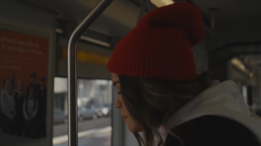 A woman gets off a bus while its stopped near a business district