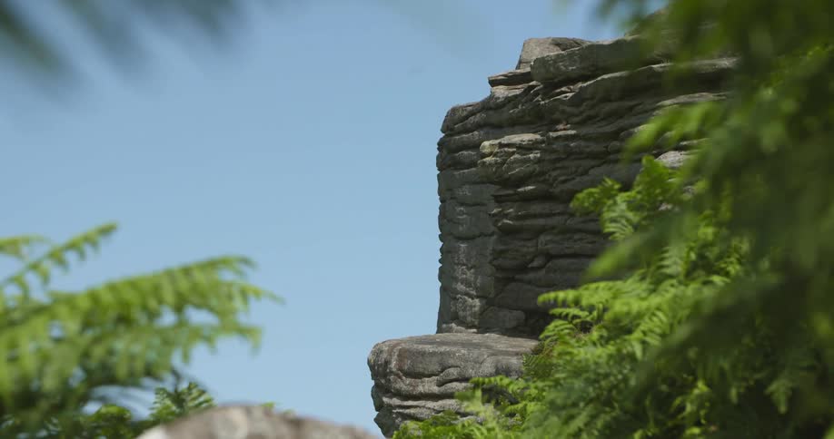 View of steep cliff seen from behind trees