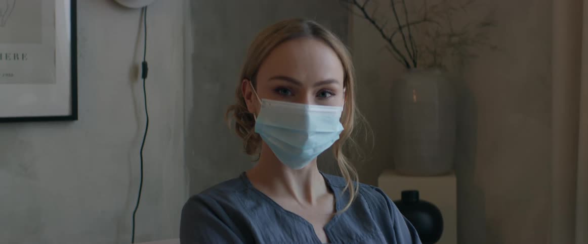 A woman standing in a room wearing a mask