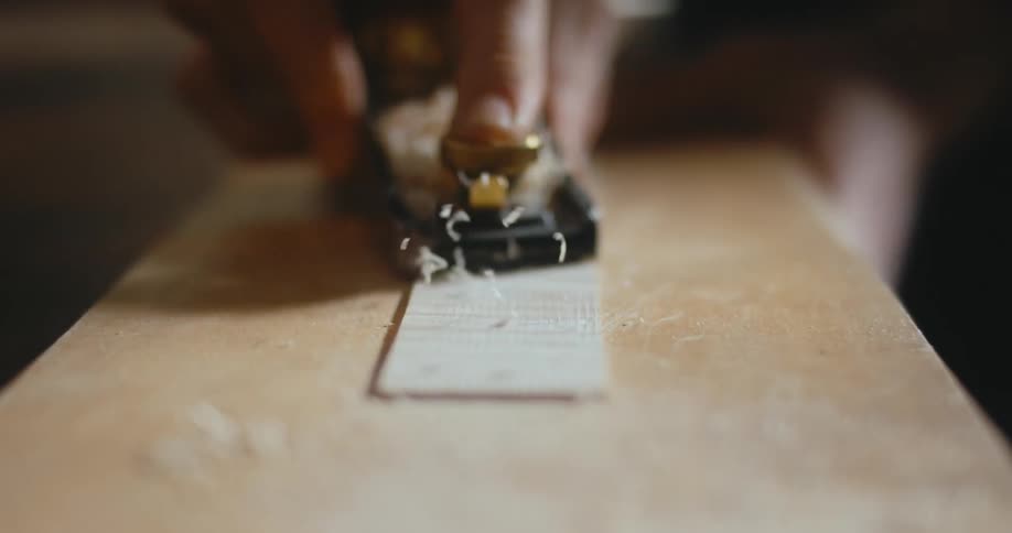Someone is rolling a hand held sander over a piece of wood