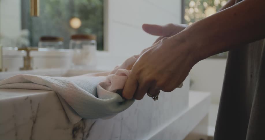 A person wipes their hands on the towel
