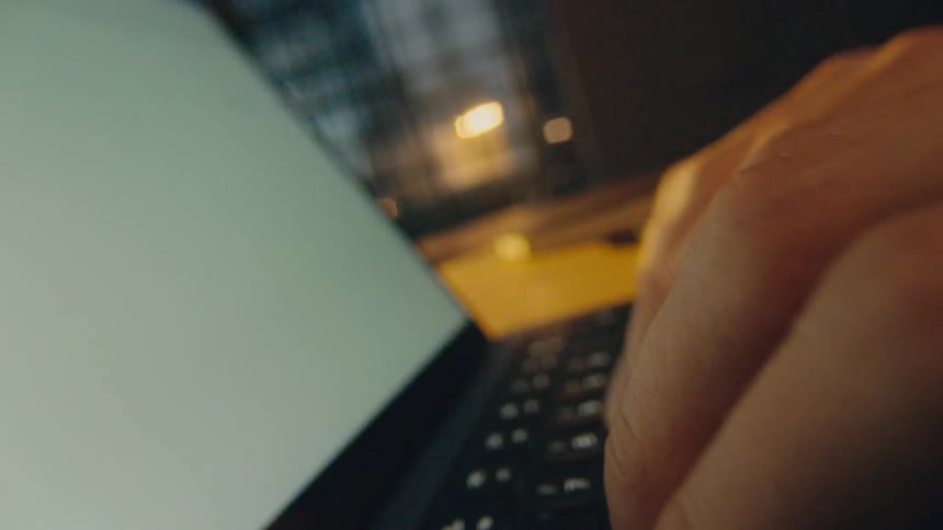 camera rotates through hands fingers typing on keyboard