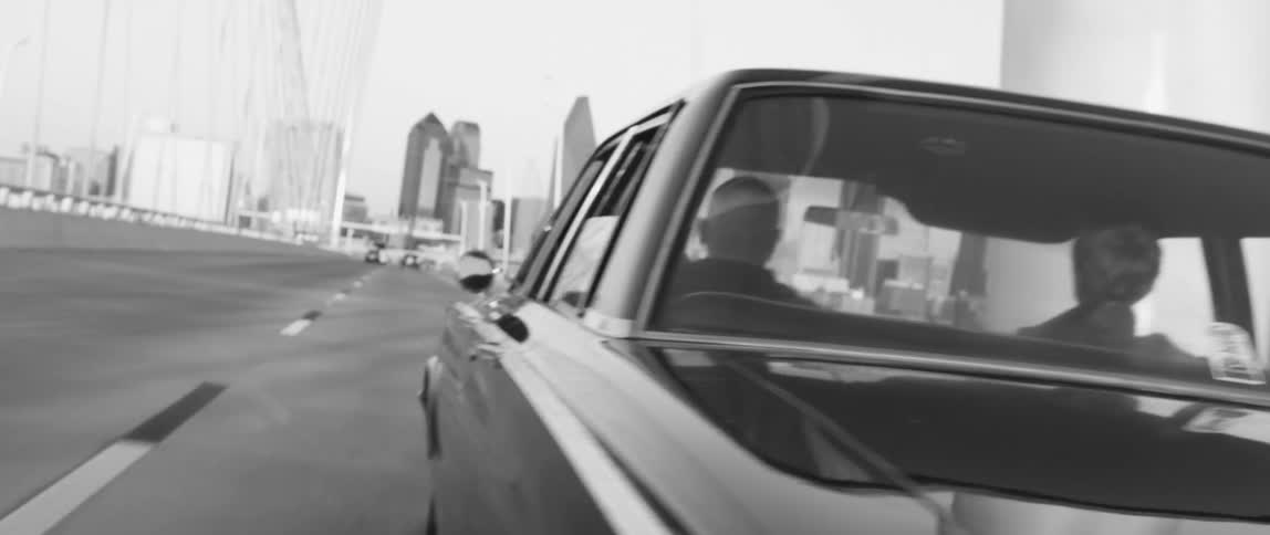 A black car drives towards the city