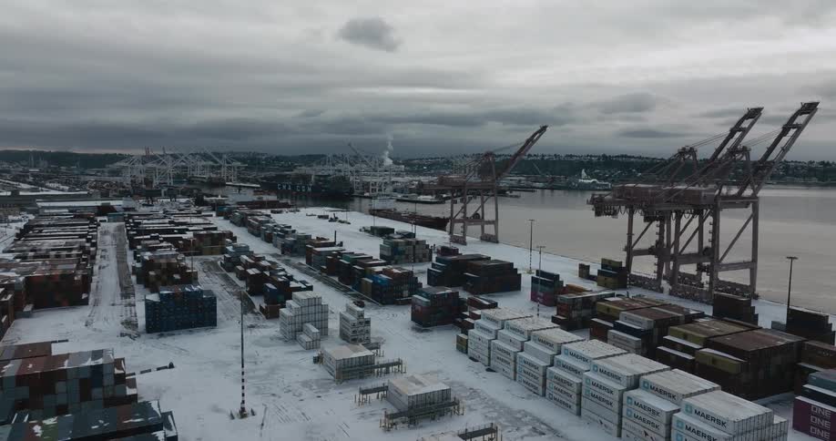 Traverse over snow covered shipping containers and equipment at an urban port facility