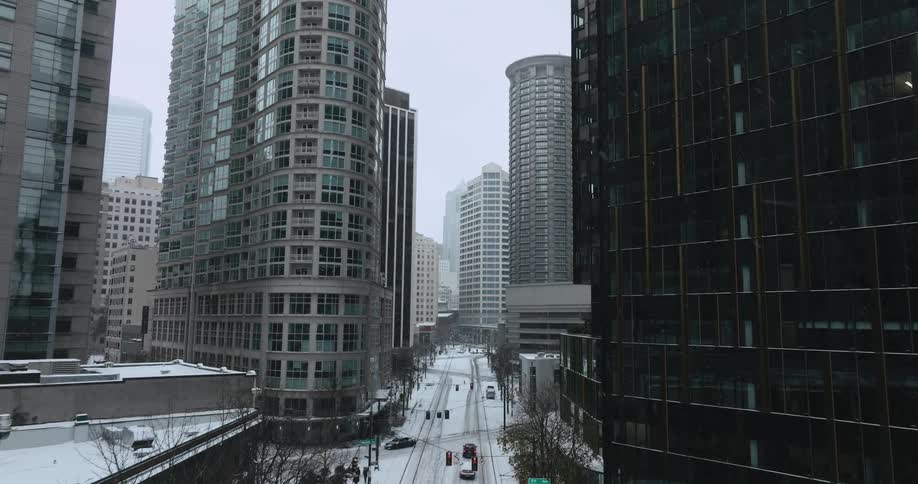Traffic and pedestrians slowly make their way along snow covered streets during a winter storm