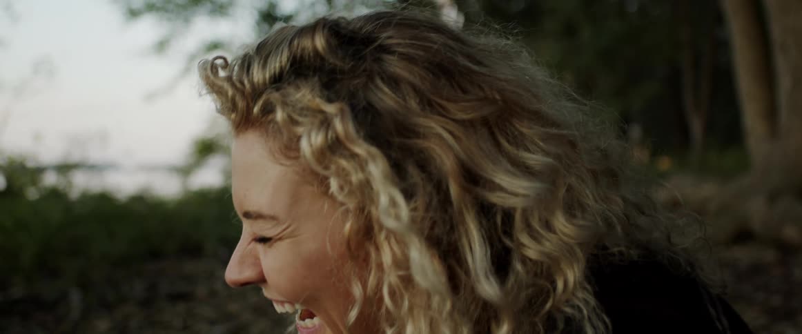 A woman is laughing outside