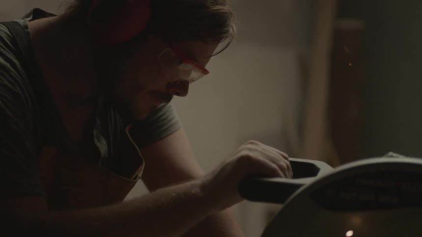 A man uses a table saw to do his work