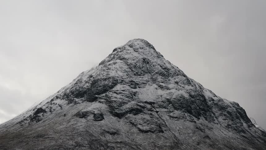 Snow covers the mountain under a cloudy sky