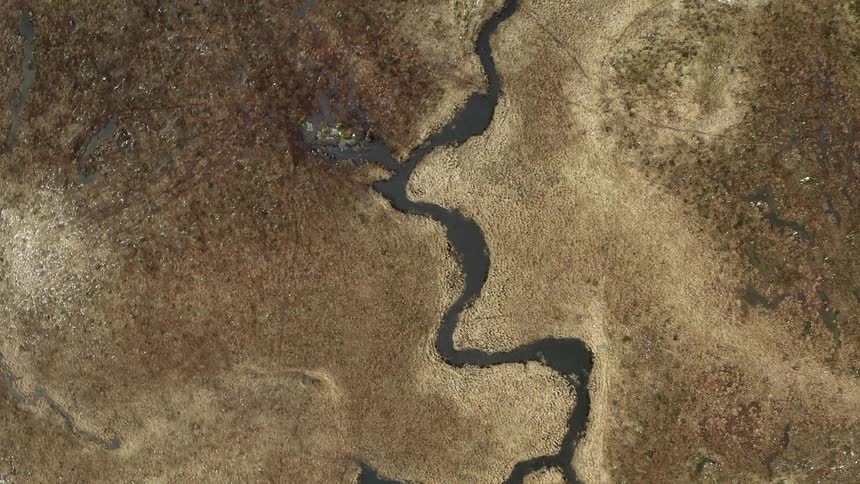 A river runs a very crooked path through an arid landscape