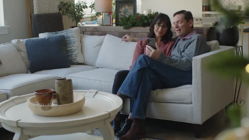 A couple talk on video with a cell phone