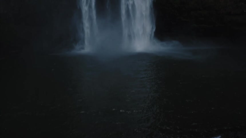 Waterfall cascading down into a dark area