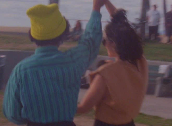A man and woman do a choreographed dance at a skate park