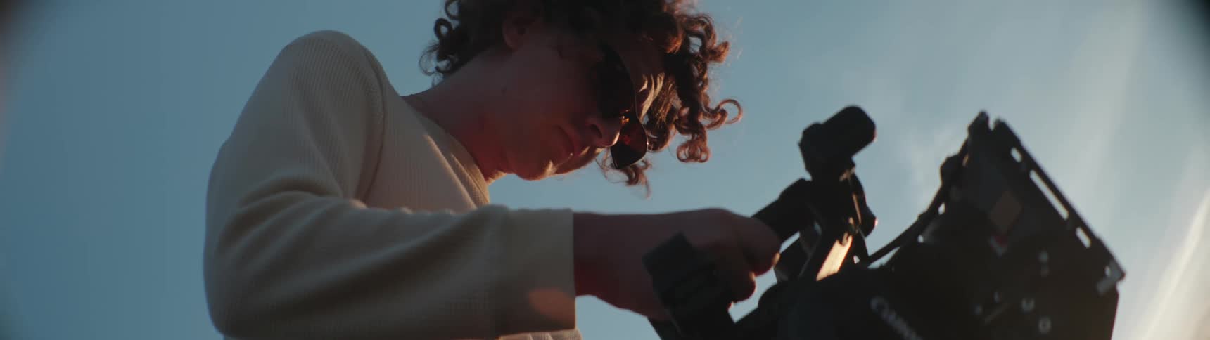 A man holding a video camera outdoors