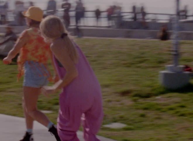 A woman waves her arms while roller skating