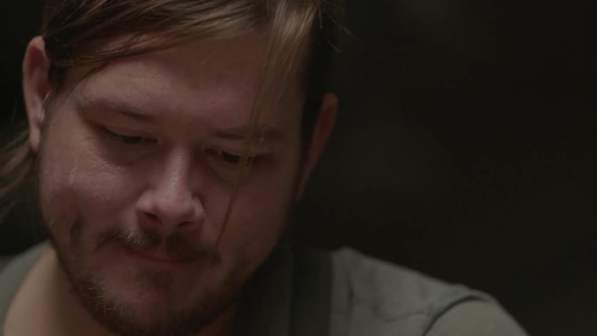 A man is smiling as he looks down