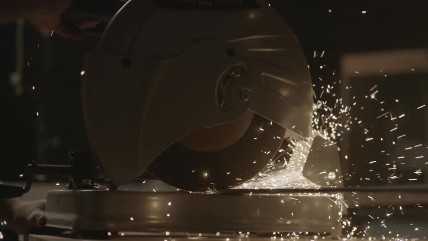 Power saw cutting metal while sparks fly