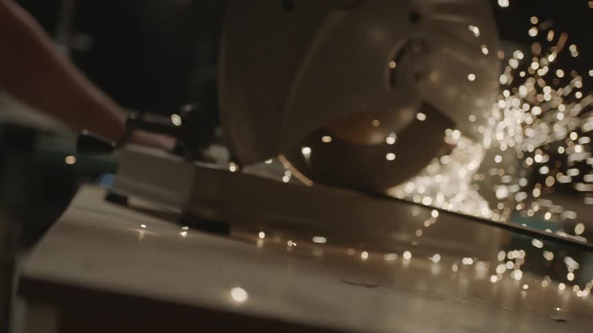 Power saw cutting metal as sparks fly