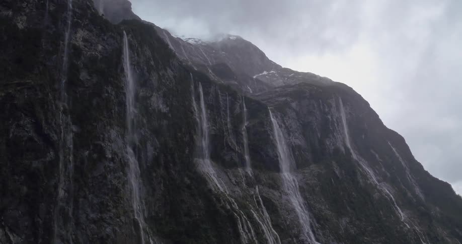 Several streamlined waterfalls flowing from high on a mountain