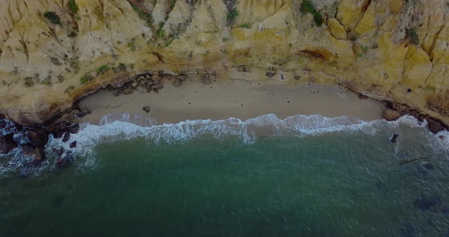 A small beach at the bottom of a cliff