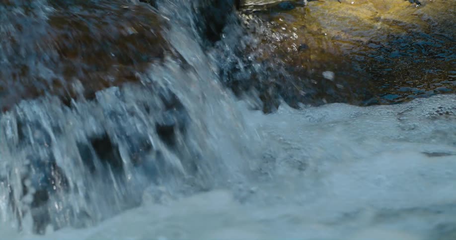 Water in a stream rushes over rocks