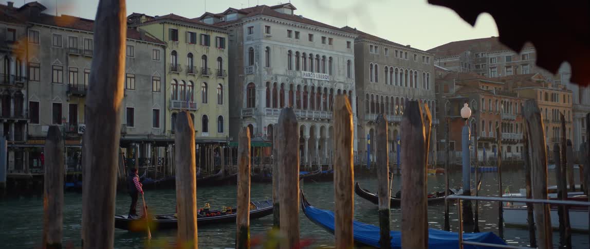 Tourists riding in gondolas and taking in the sights at sunset along the Grand Canal in Venice, Italy