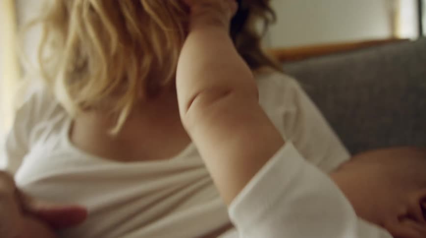 A mother holding her baby in a room