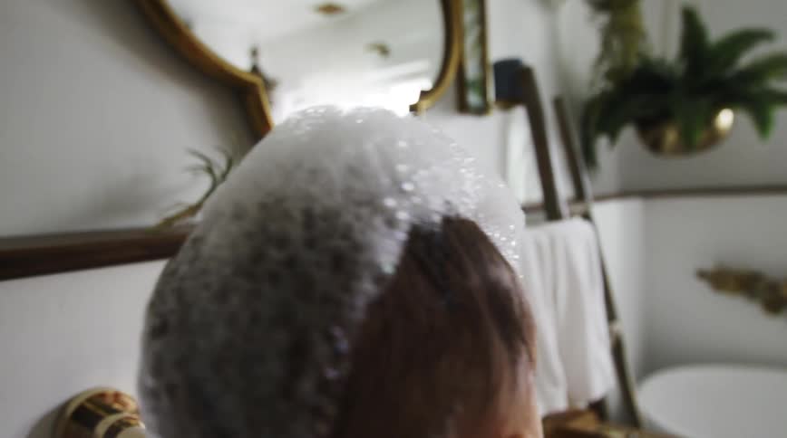 Mother washes baby in bathroom sink