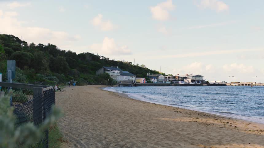Ocean waves gently wash upon an inviting sandy beach
