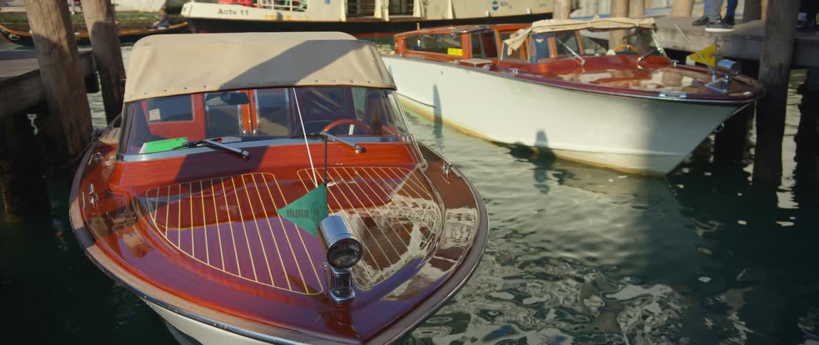 Water taxis docked along the canal as other boats float by in Venice, Italy