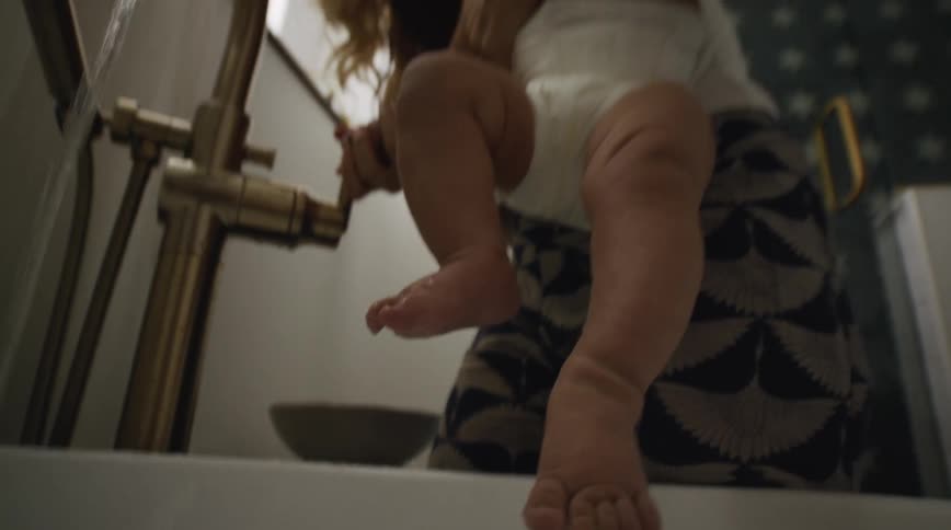 A woman is pouring a bath for her baby