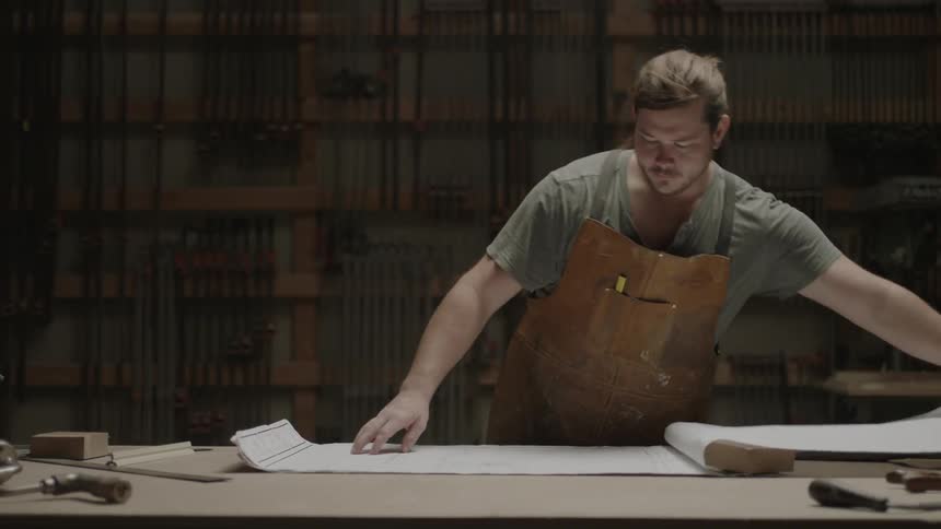 Man studying blueprints in his workshop
