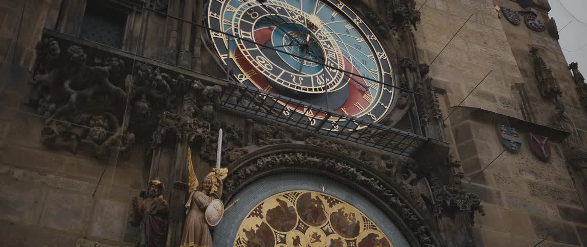 View of the Prague Orloj panning up from the Calendar Plate surrounded by figures below, and the Astronomical Clock Dial above.