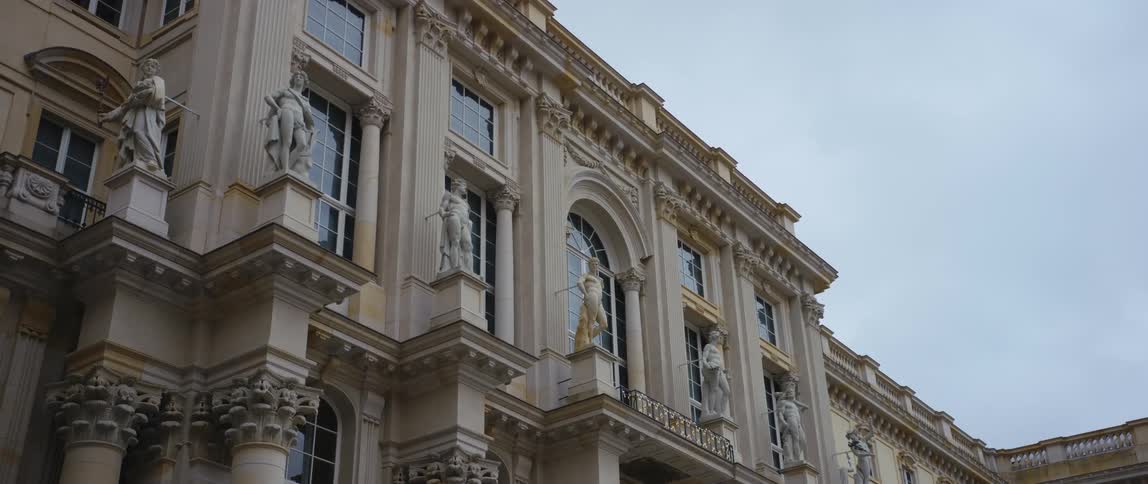 Statues atop the ornate columns along the facade of the reconstructed Berlin Royal Palace which houses the Humboldt Forum museum.