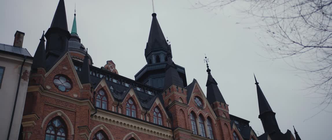 A large steepled building under a cloudy daytime sky