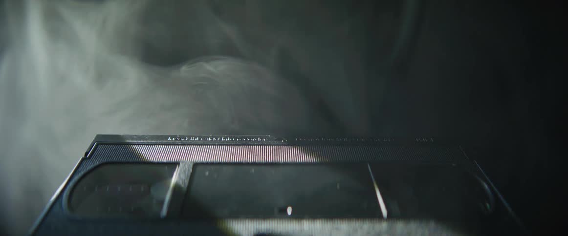 Light flashes near a black vcr tape as smoke rises nearby