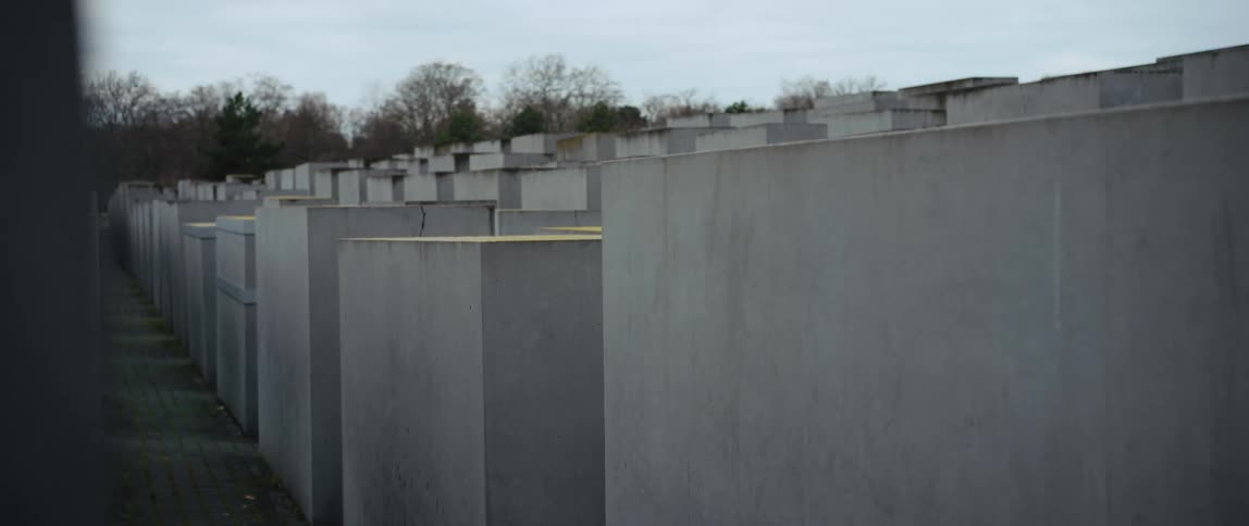 POV walking from behind and among the thousands of concrete slabs commemorating the murdered Jews of Europe during the Second World War in Berlin, Germany